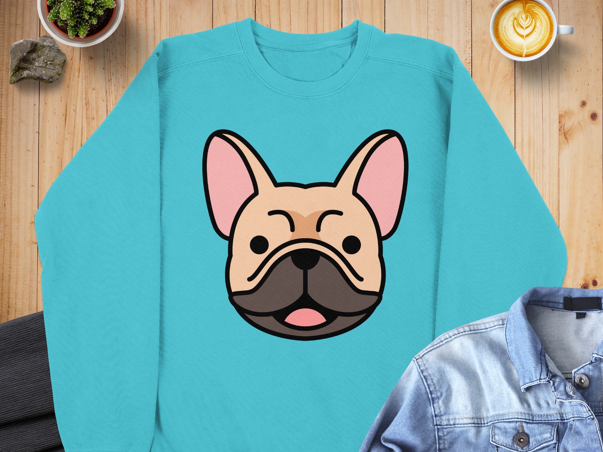 Teal sweatshirt featuring a cartoon French Bulldog face with closed eyes.
