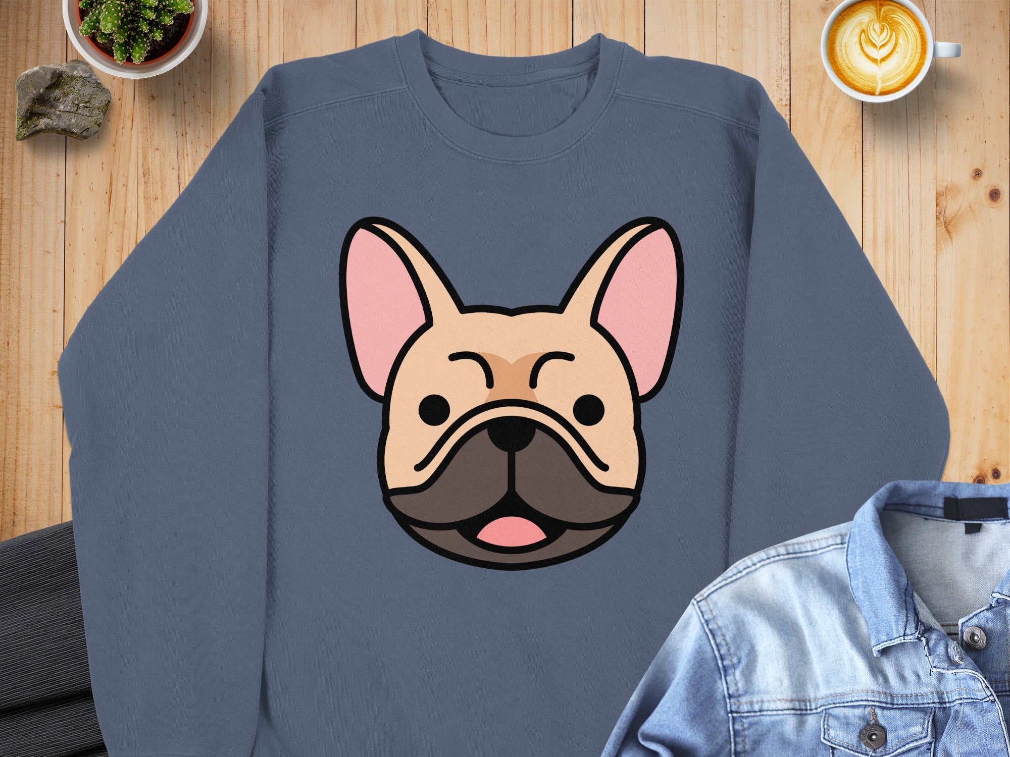 French bulldog graphic on a navy sweatshirt, laid flat with denim jacket and coffee.
